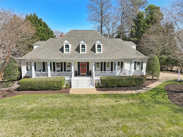 view of front of home with a porch, a chimney, a front lawn, and a shingled roof