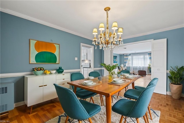 dining room featuring a chandelier, radiator, baseboards, and ornamental molding