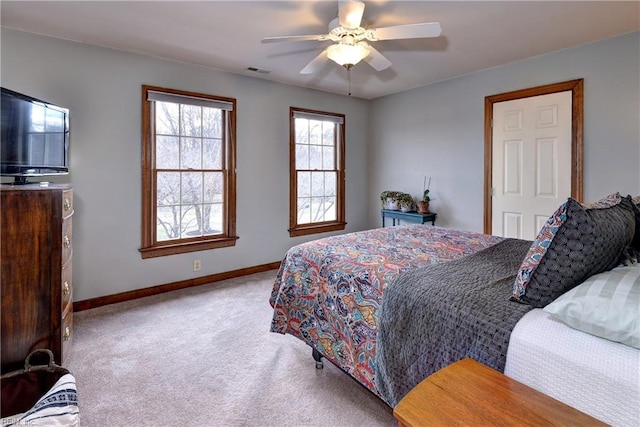 carpeted bedroom with visible vents, a ceiling fan, and baseboards