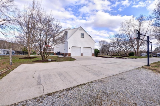 view of side of property featuring concrete driveway and a garage