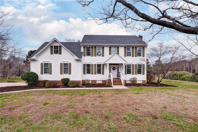 colonial inspired home with a front lawn, crawl space, roof with shingles, and a chimney