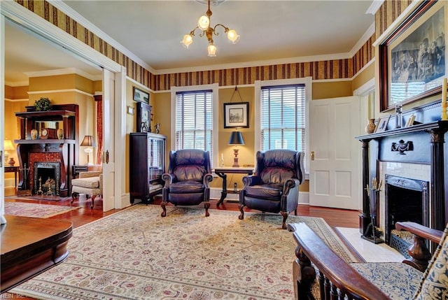 living room featuring crown molding, a notable chandelier, a fireplace, and wood finished floors