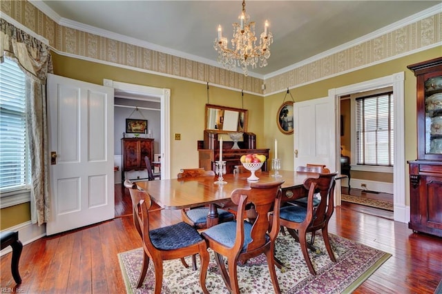 dining space featuring baseboards, dark wood-type flooring, an inviting chandelier, and ornamental molding