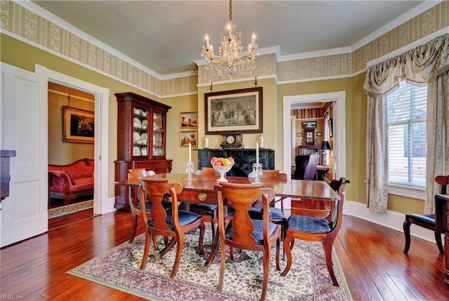 dining area with baseboards, a notable chandelier, ornamental molding, and hardwood / wood-style flooring