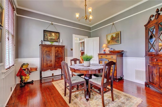 dining room with a chandelier, visible vents, wainscoting, and wood-type flooring