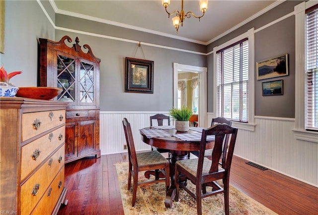 dining room with visible vents, a wainscoted wall, dark wood-style flooring, and a chandelier