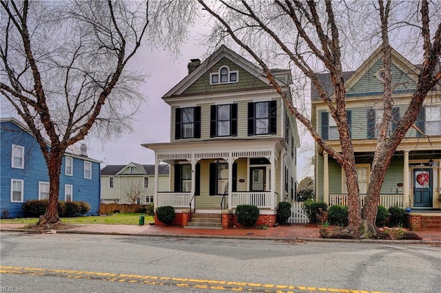 view of front facade featuring covered porch and a chimney