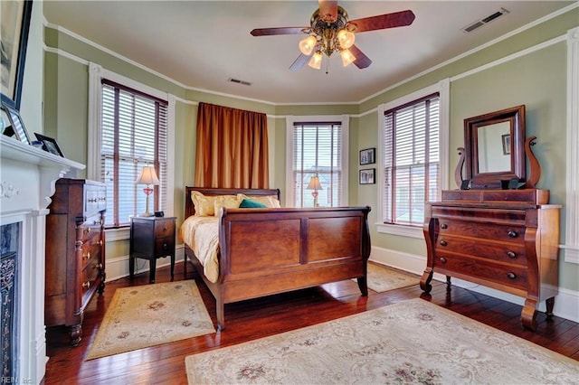 bedroom featuring visible vents, wood-type flooring, baseboards, and crown molding