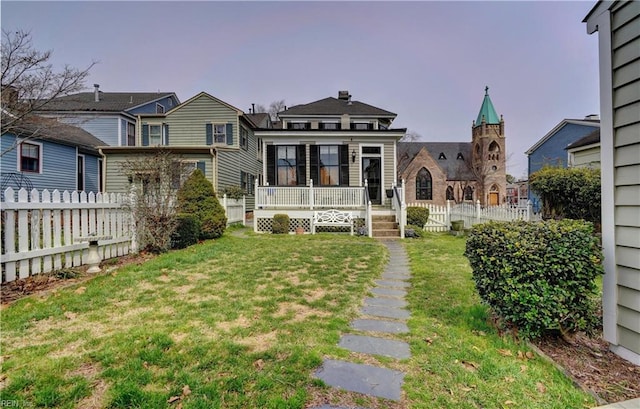 back of property with fence and a lawn