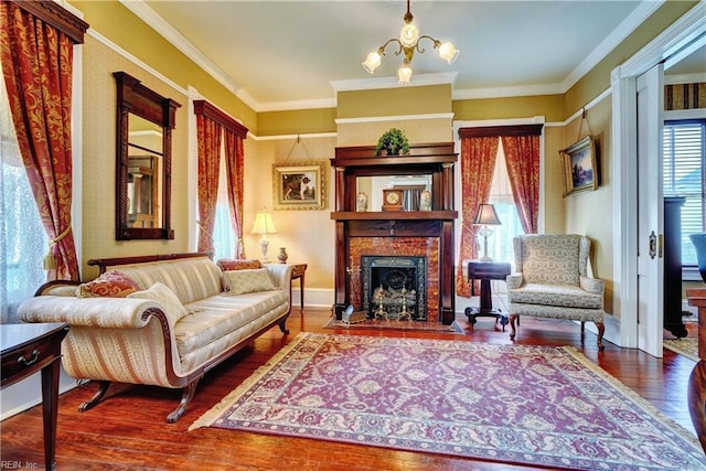 living area with a fireplace with flush hearth, an inviting chandelier, wood finished floors, and ornamental molding