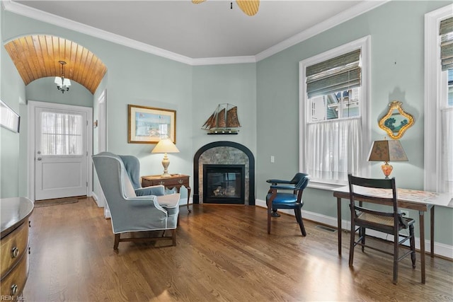 sitting room with visible vents, ornamental molding, a glass covered fireplace, wood finished floors, and baseboards