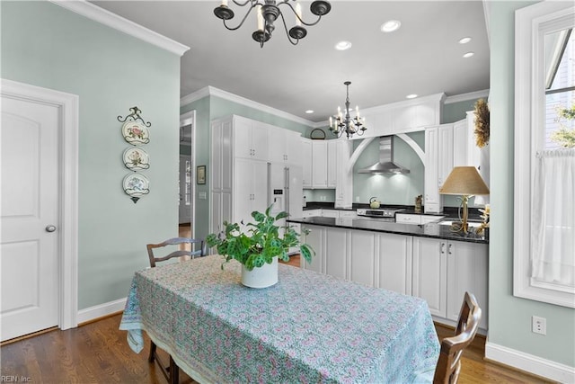 dining room with dark wood-type flooring, baseboards, crown molding, and an inviting chandelier