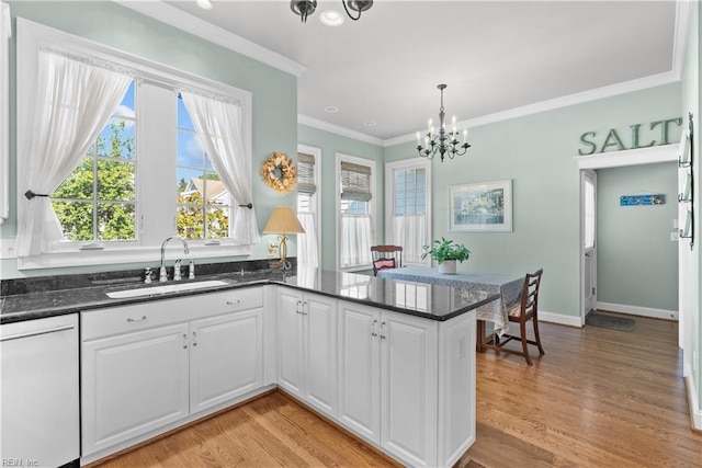 kitchen featuring light wood-type flooring, a peninsula, white dishwasher, white cabinetry, and a sink