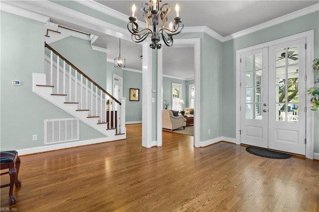 entrance foyer with visible vents, baseboards, stairway, french doors, and wood finished floors