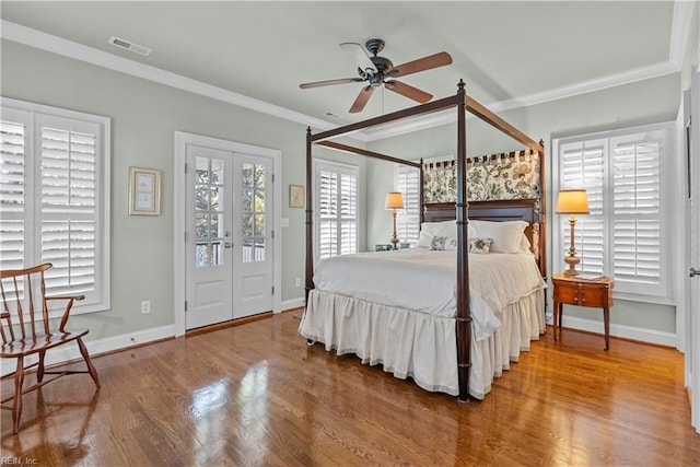 bedroom featuring access to exterior, crown molding, wood finished floors, and visible vents