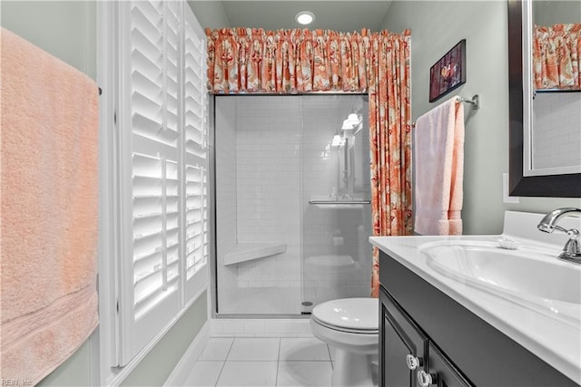 full bath with toilet, a stall shower, vanity, and tile patterned flooring