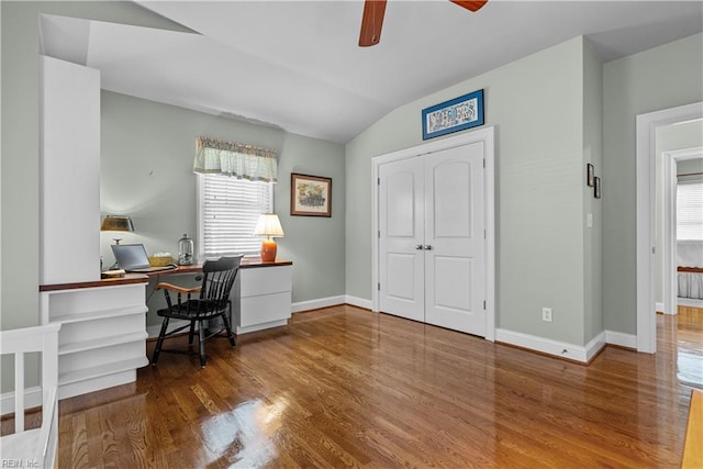 home office featuring a ceiling fan, lofted ceiling, wood finished floors, and baseboards