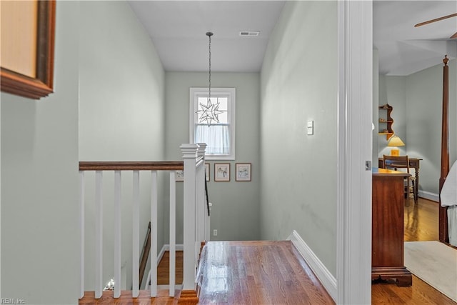 foyer featuring visible vents, a ceiling fan, baseboards, and wood finished floors