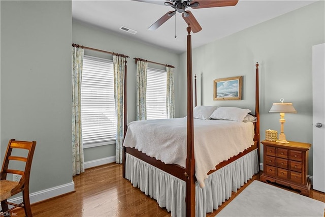 bedroom with visible vents, ceiling fan, baseboards, and wood finished floors