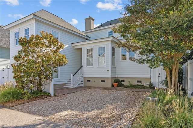 view of front facade featuring crawl space, entry steps, and fence