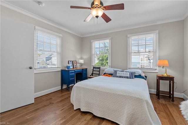 bedroom featuring crown molding, wood finished floors, baseboards, and ceiling fan