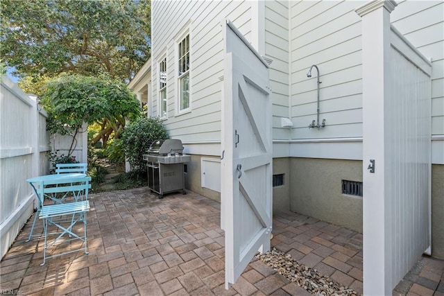 view of patio with area for grilling and fence