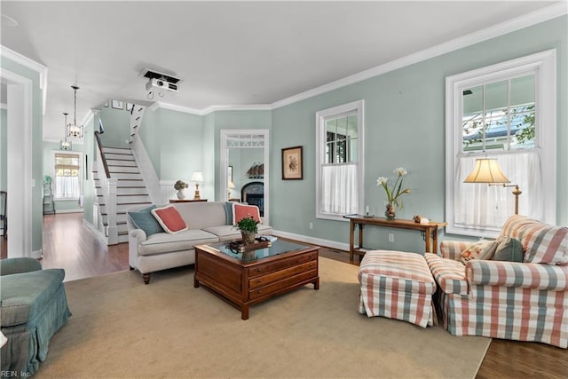 living room with crown molding, baseboards, stairway, a fireplace, and wood finished floors