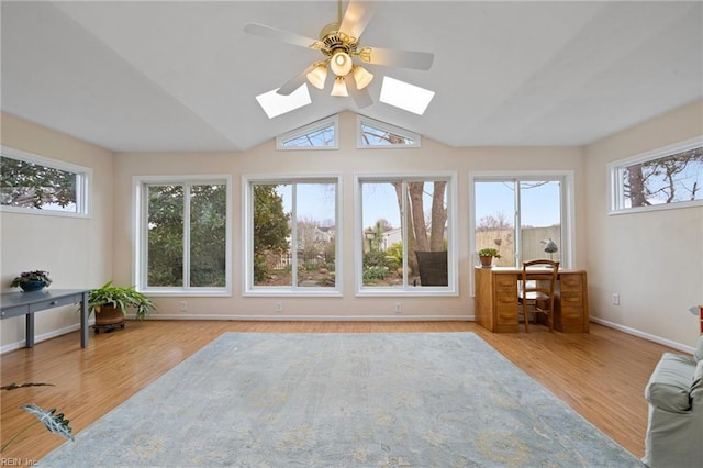 sunroom / solarium featuring vaulted ceiling with skylight and ceiling fan