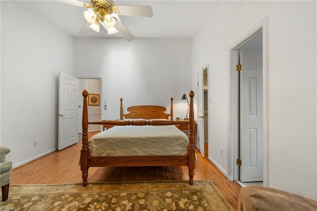 bedroom featuring wood finished floors, baseboards, and ceiling fan