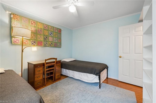 bedroom featuring wood finished floors, a ceiling fan, and ornamental molding