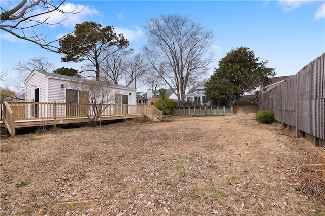 view of yard with a wooden deck and a fenced backyard