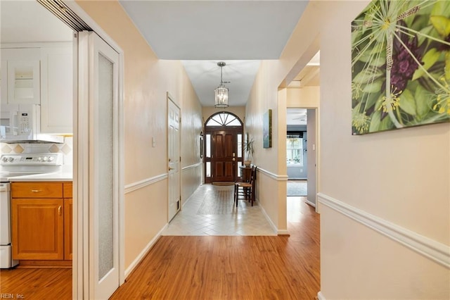 foyer entrance with light wood-type flooring and baseboards