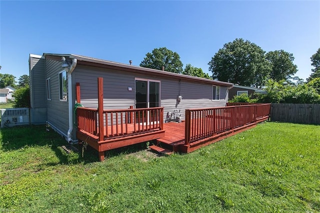 back of property featuring a wooden deck, a lawn, cooling unit, and fence