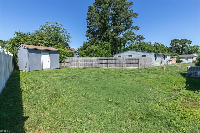 view of yard featuring a storage shed, a fenced backyard, and an outdoor structure