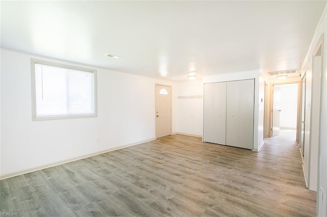 unfurnished bedroom with a closet, visible vents, and wood finished floors