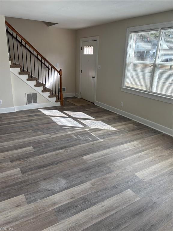 foyer entrance featuring stairway, baseboards, visible vents, and wood finished floors