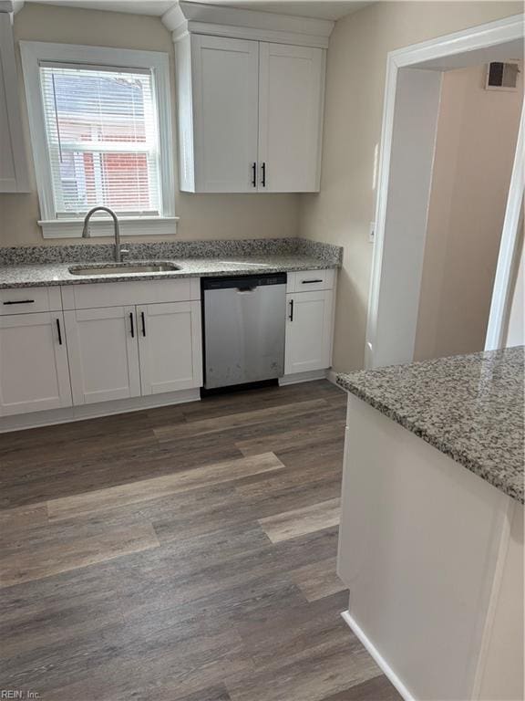 kitchen with a sink, dark wood-style floors, dishwasher, and white cabinets