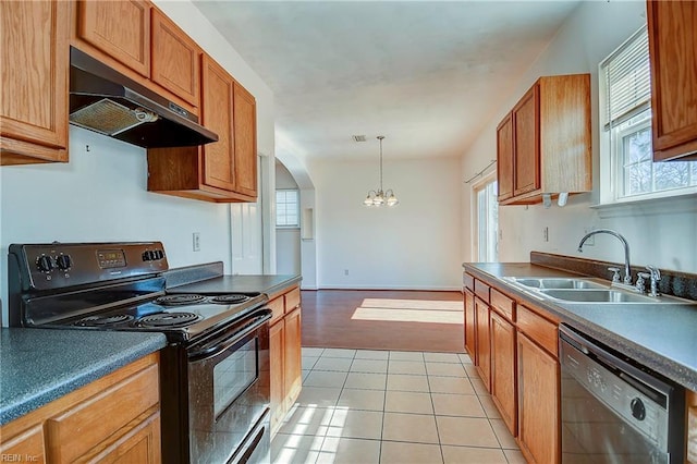 kitchen with under cabinet range hood, black appliances, a wealth of natural light, and a sink