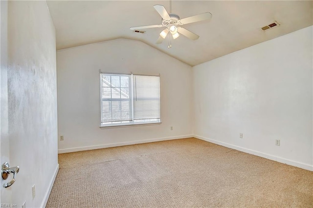 carpeted spare room with visible vents, baseboards, a ceiling fan, and vaulted ceiling