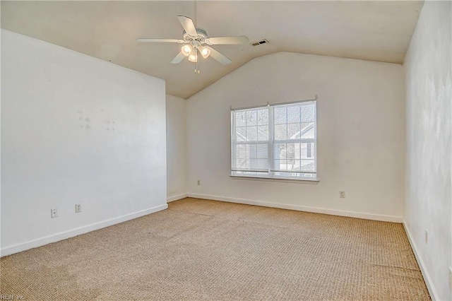 spare room featuring visible vents, ceiling fan, baseboards, vaulted ceiling, and carpet floors