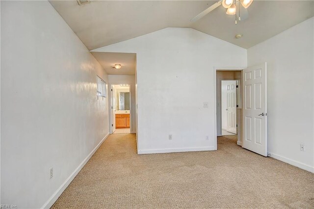 unfurnished bedroom featuring baseboards, lofted ceiling, and carpet floors