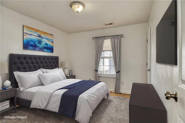 bedroom with visible vents and wood finished floors