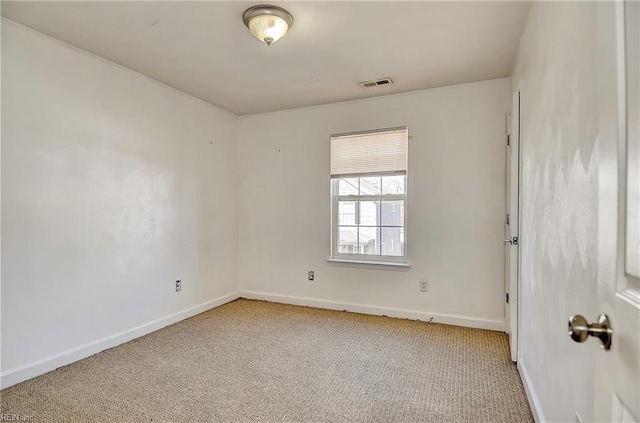 carpeted empty room featuring baseboards and visible vents