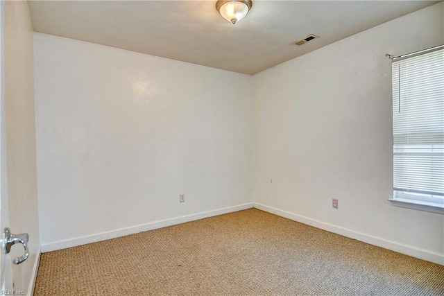 empty room with visible vents, baseboards, and light carpet