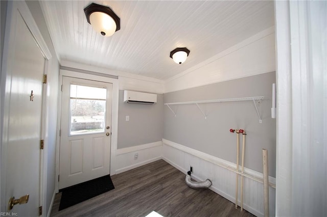 clothes washing area with laundry area, a wall mounted air conditioner, and dark wood-type flooring