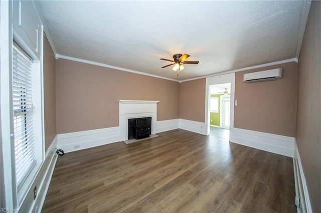 unfurnished living room with ceiling fan, ornamental molding, wood finished floors, and a wall mounted AC