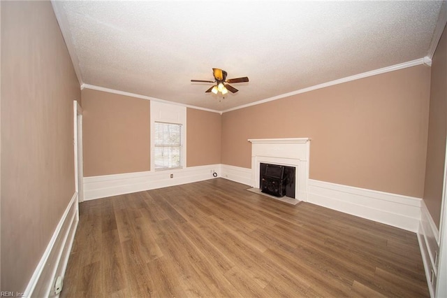 unfurnished living room featuring ornamental molding, a textured ceiling, a ceiling fan, and wood finished floors