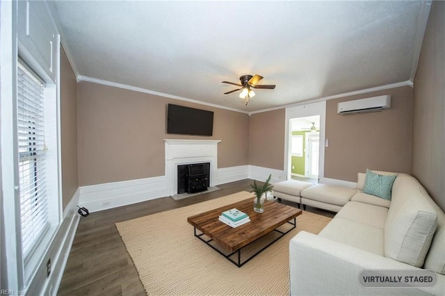 living area with wood finished floors, ceiling fan, crown molding, and a wall mounted AC