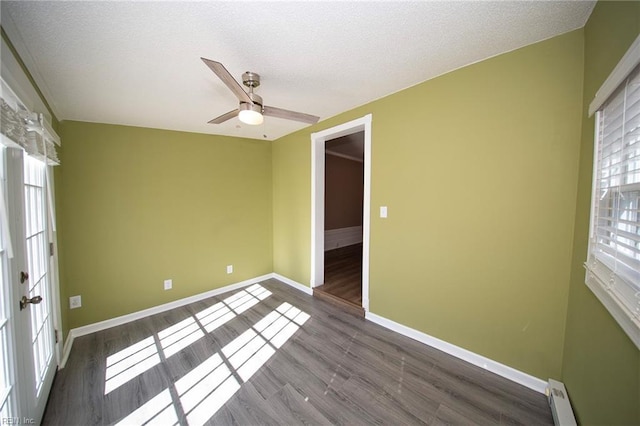 unfurnished room with wood finished floors, baseboards, ceiling fan, a textured ceiling, and baseboard heating