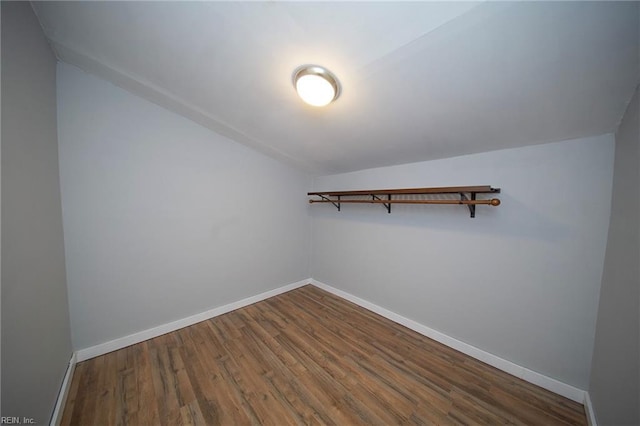 spacious closet featuring wood finished floors and vaulted ceiling